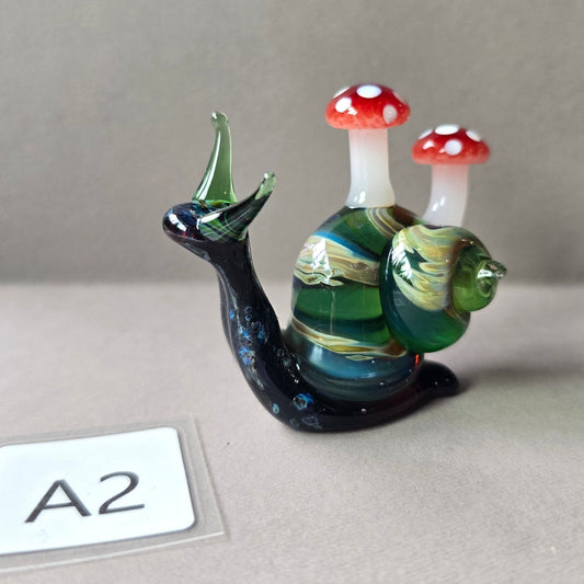 Glass snail figurine with mushroom-shaped shells on a gray background