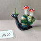Glass snail figurine with mushroom-shaped shells on a gray background